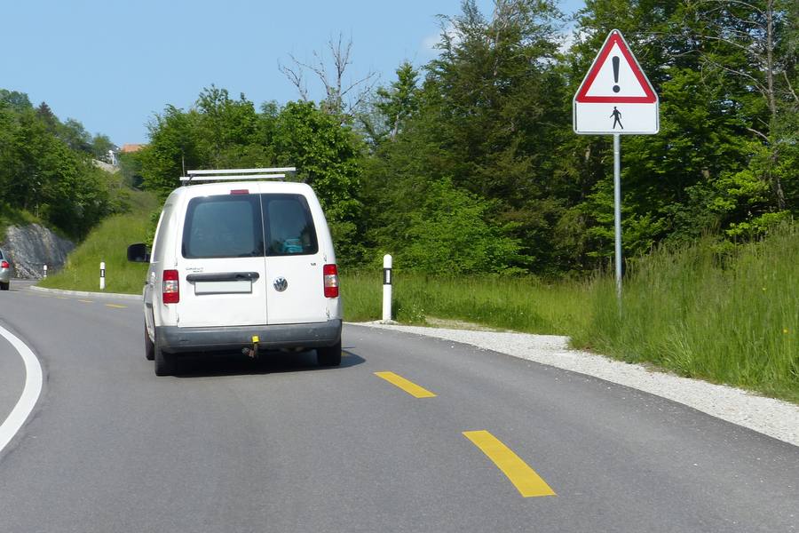Pedestrian warning sign on a Swiss road, awareness course